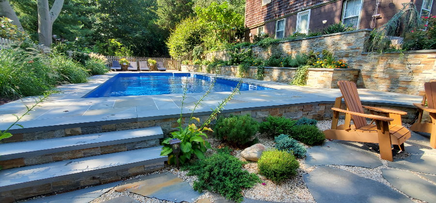 Bluestone patio around pool with retaining walls